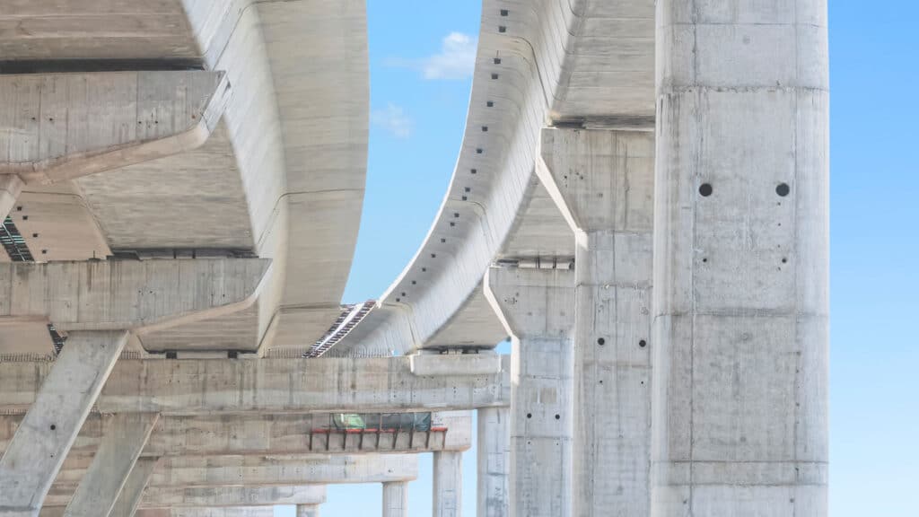 Precast concrete bridge with curved supports and sturdy columns, showcasing modern infrastructure and architectural design.