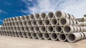 Stacked precast concrete drainage pipes at a production facility, illustrating low-waste modular construction for sustainable infrastructure.