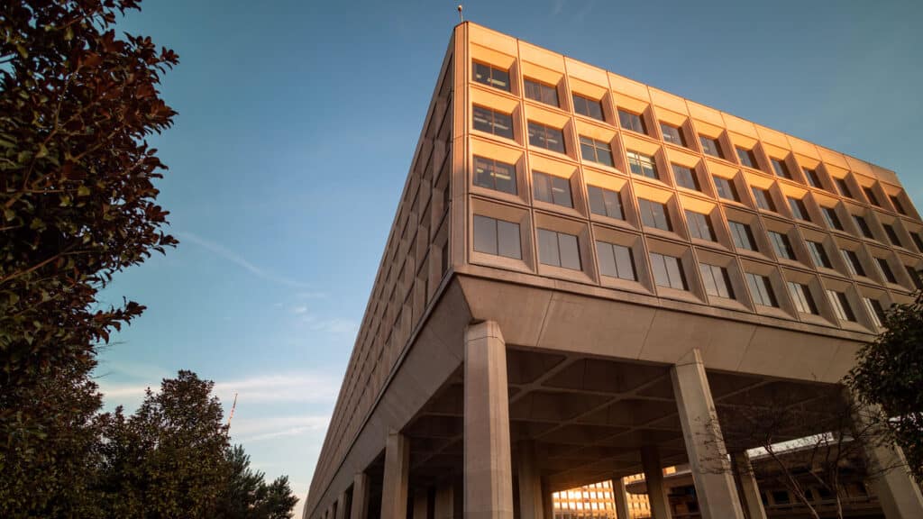 A modern building with a precast concrete facade, elevated on pillars, showcasing sustainable design.