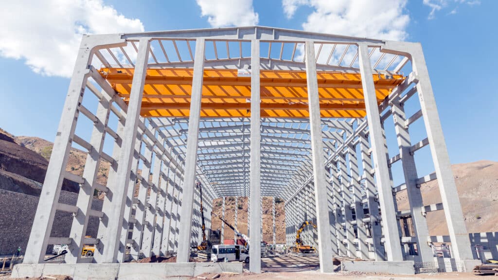 A large industrial building under construction with a precast concrete frame, showcasing sustainable design.